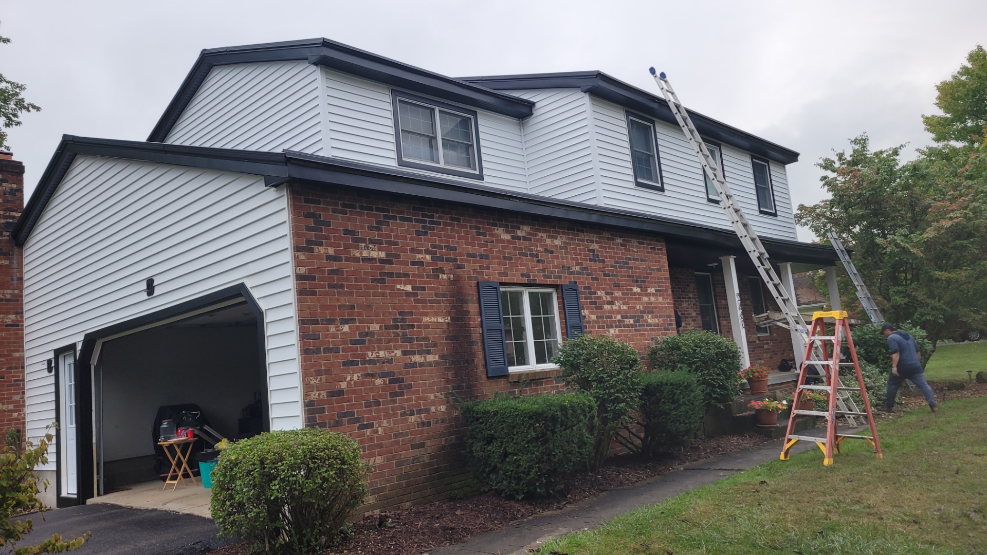 Vinyl siding re-side with white lap siding and brick base