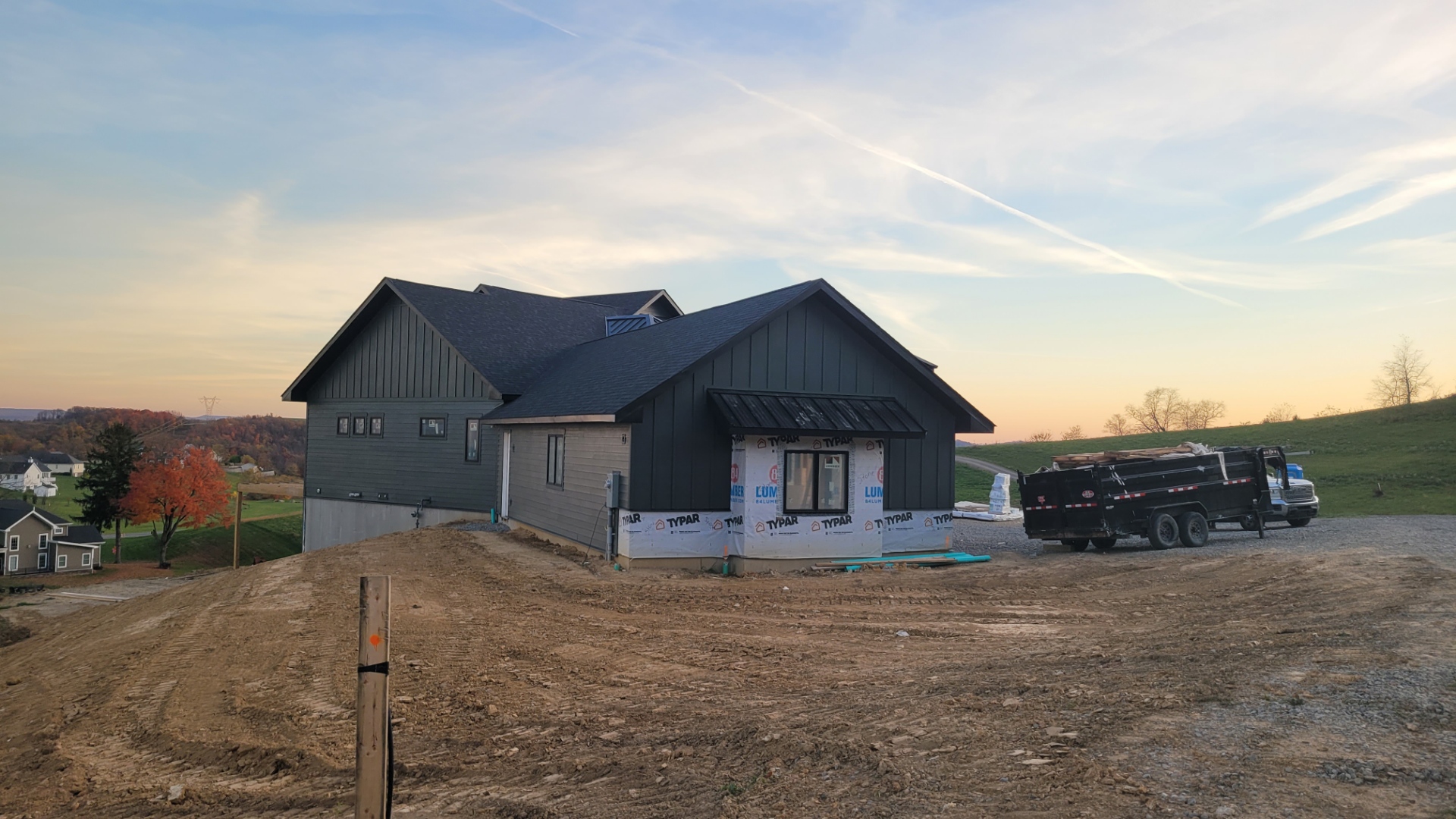 New construction home with dark green board and batten siding