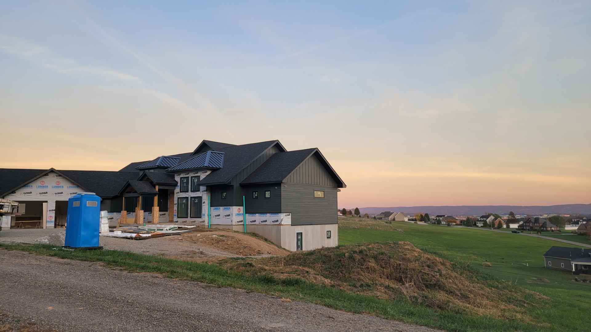 Custom home with board and batten siding at dusk